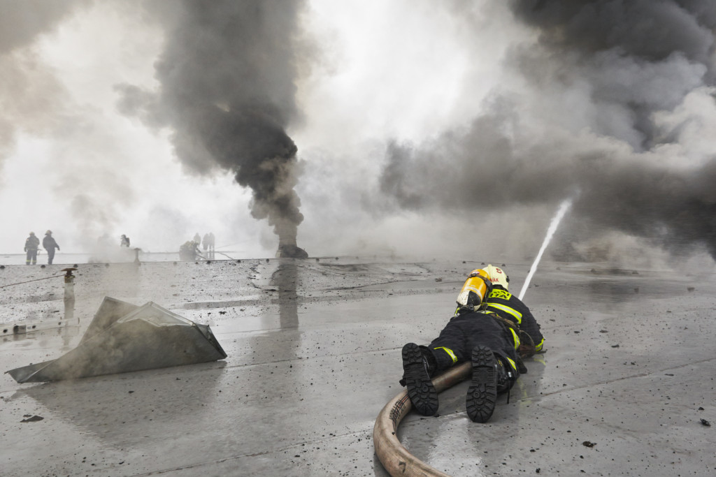 Hasiči na střeše hořícího velkoskladu v pražské Libuši - Foto: Jaromír Chalabala